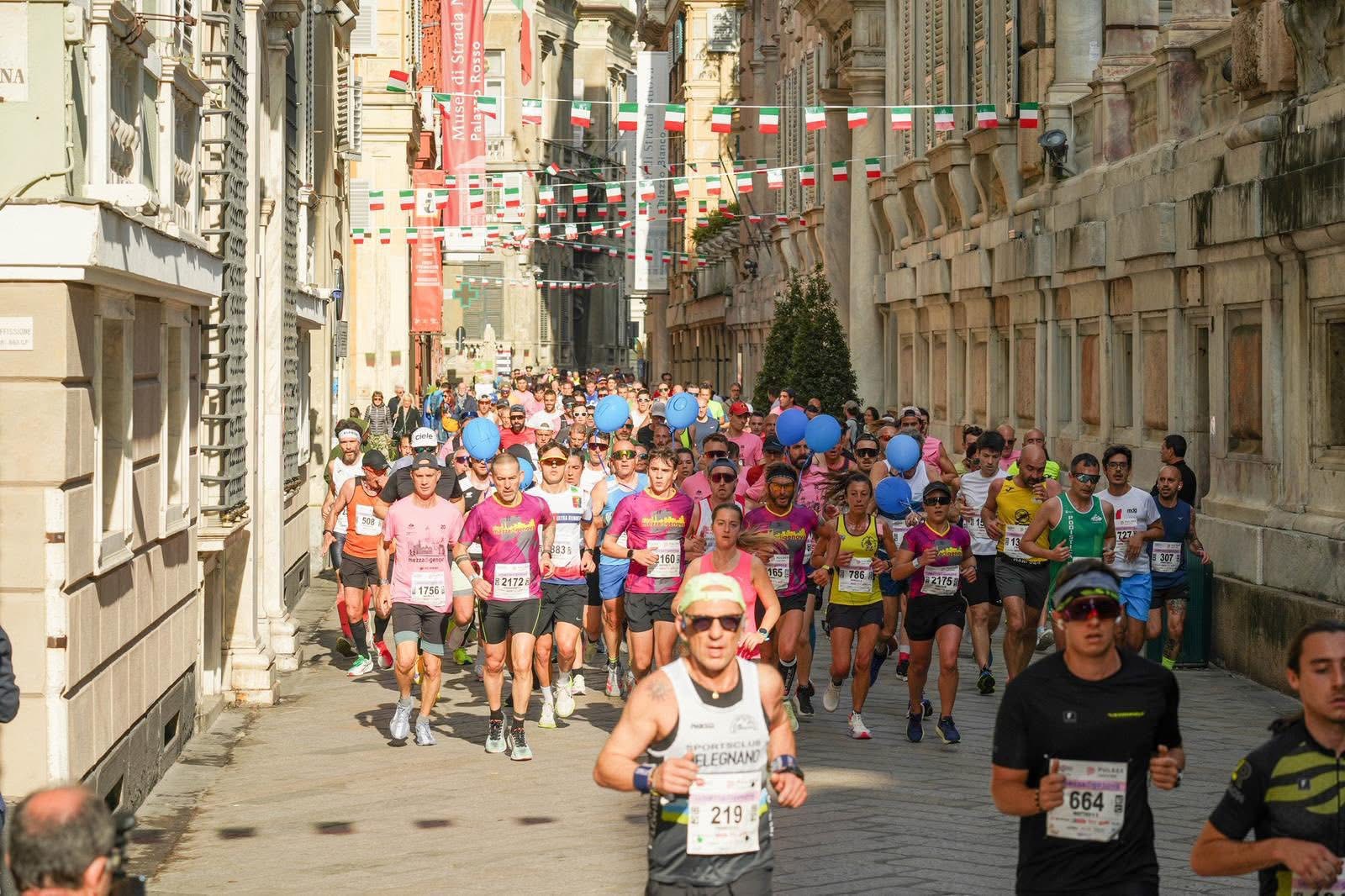 A group of Mezza Maratona participants running along Via Garibaldi, in Genova.